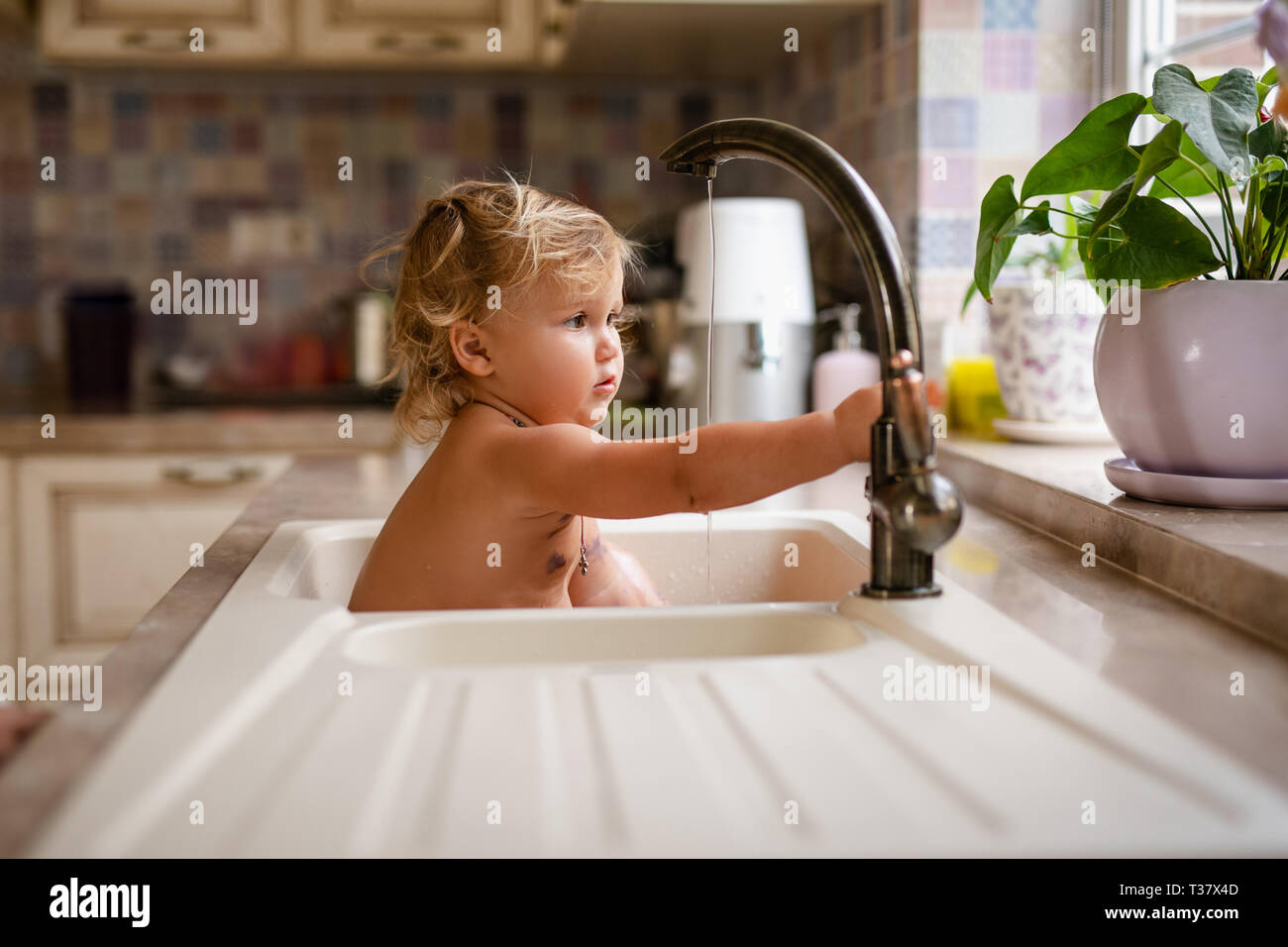 Image for Images reveal baby playing in a sink, not published out of respect