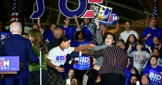 Protesters rush the stage during Biden